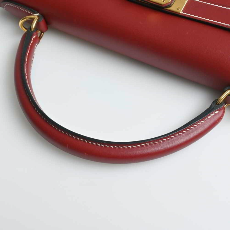 Bolso Hermes Kelly 32 en color burdeos, viene con correa para el hombro, clochette y Cadena.