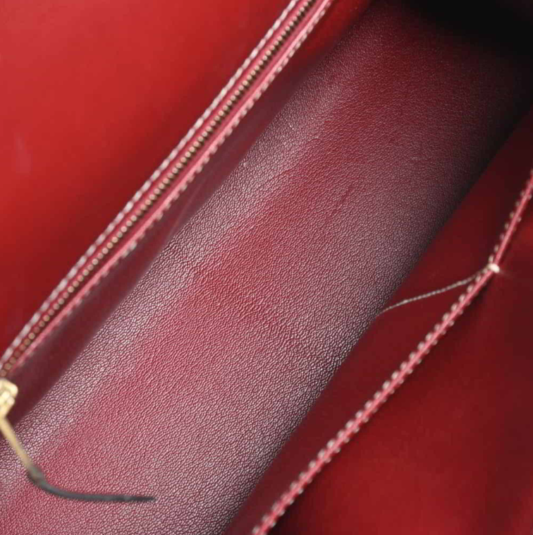 Bolso Hermes Kelly 32 en color burdeos, viene con correa para el hombro, clochette y Cadena.