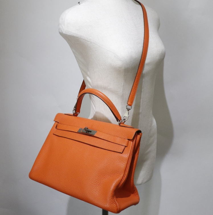 El bolso Clemence de cuero naranja Hermes Kelly 32 viene con accesorios