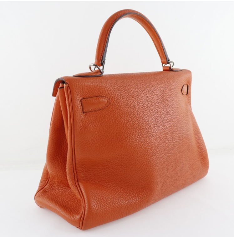 El bolso Clemence de cuero naranja Hermes Kelly 32 viene con accesorios