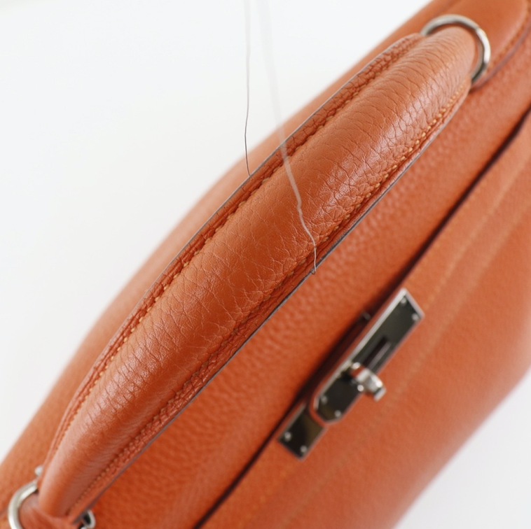 El bolso Clemence de cuero naranja Hermes Kelly 32 viene con accesorios