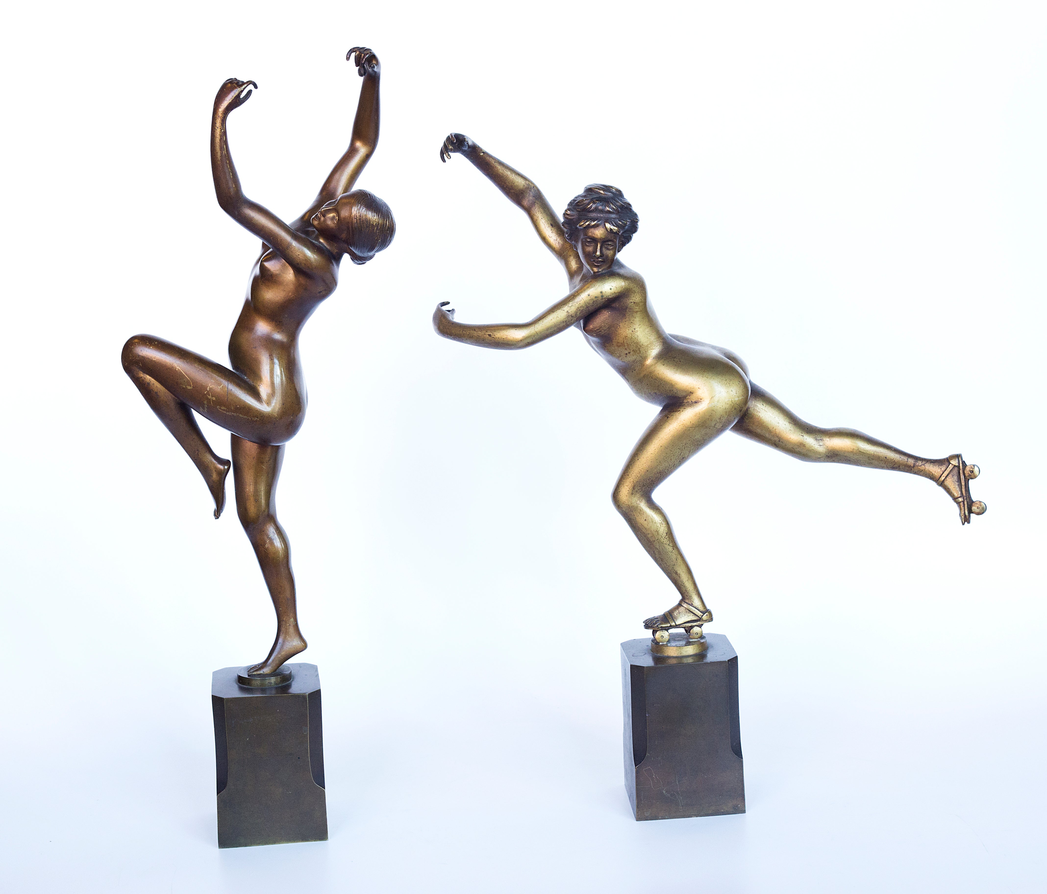 A pair showcases exquisite bronze Art Deco sculptures by H. Calot: "Nude Dancer" and "Roller Skater."
