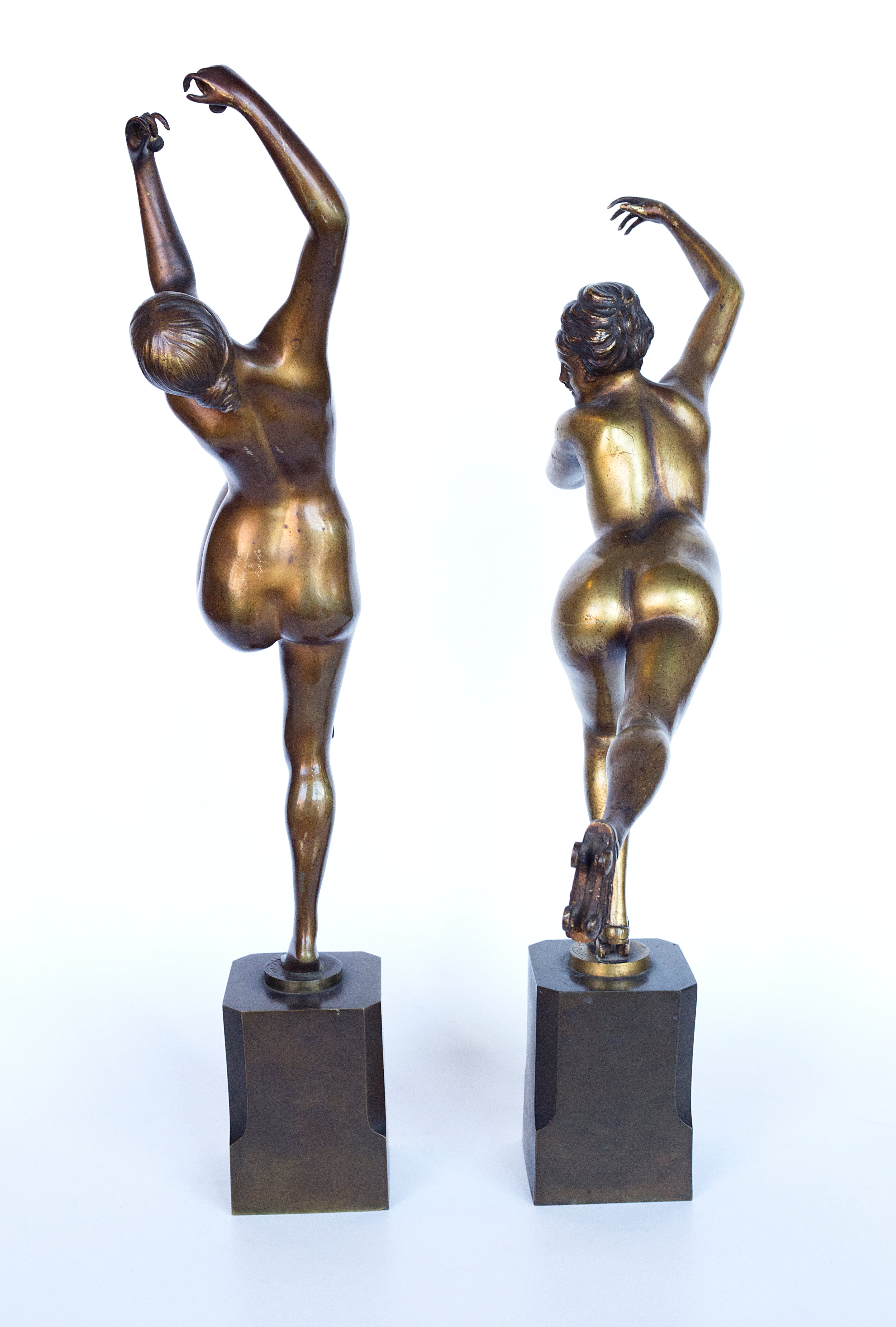 A pair showcases exquisite bronze Art Deco sculptures by H. Calot: "Nude Dancer" and "Roller Skater."