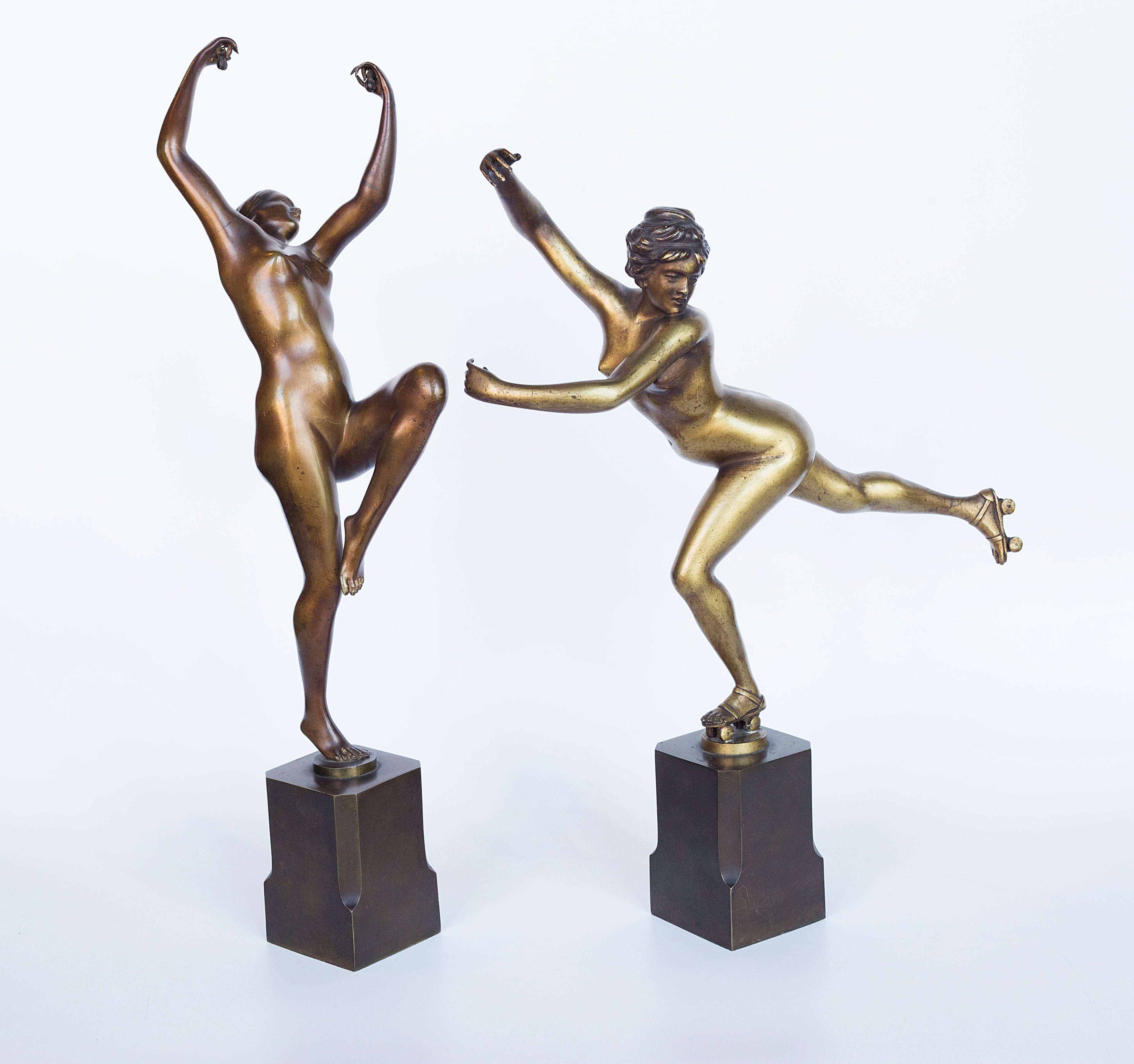 A pair showcases exquisite bronze Art Deco sculptures by H. Calot: "Nude Dancer" and "Roller Skater."