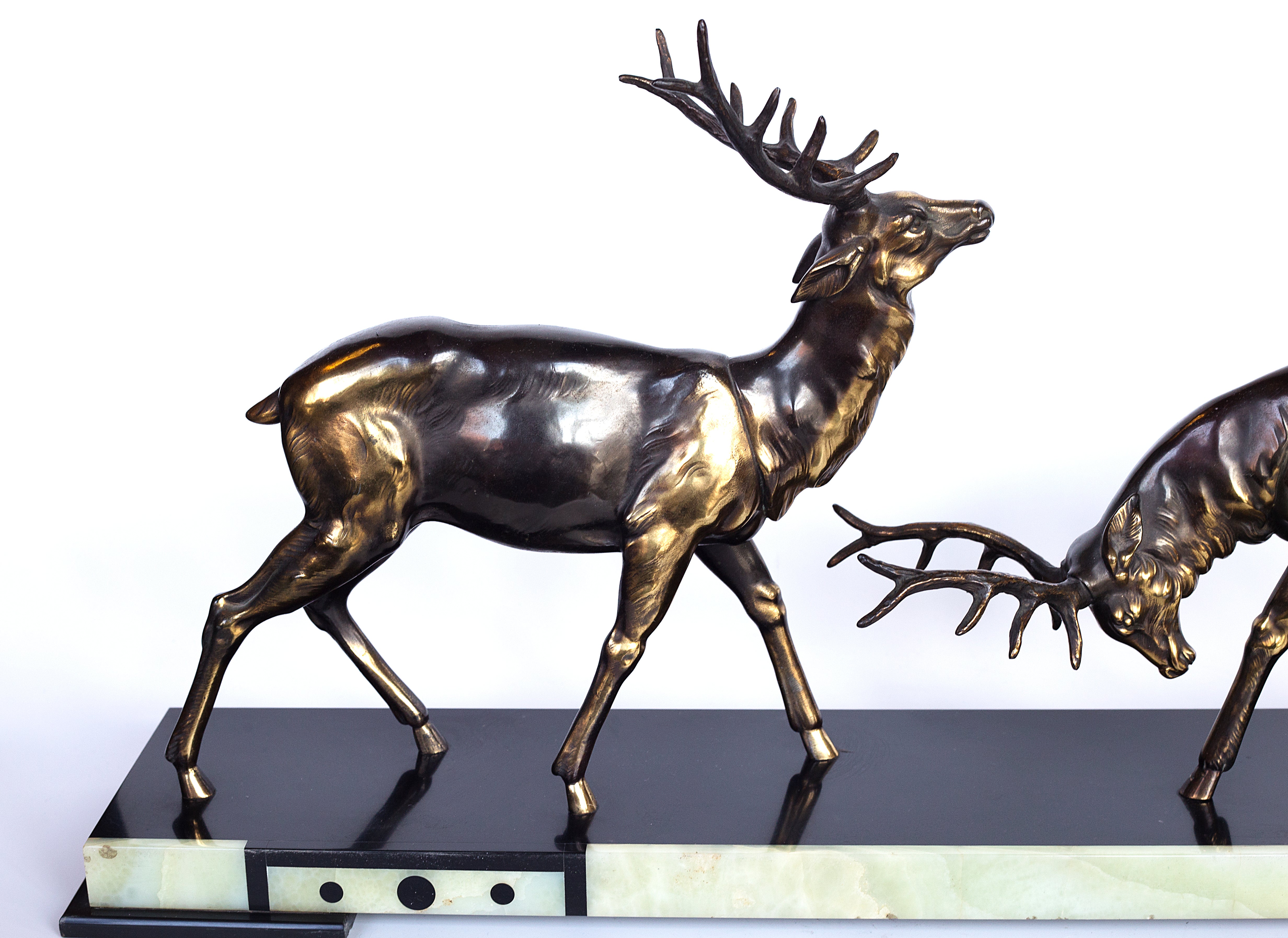 A 1930s Art Deco sculpture by Limousin captures the elegance of two deers poised gracefully atop a striking multi-colored marble base