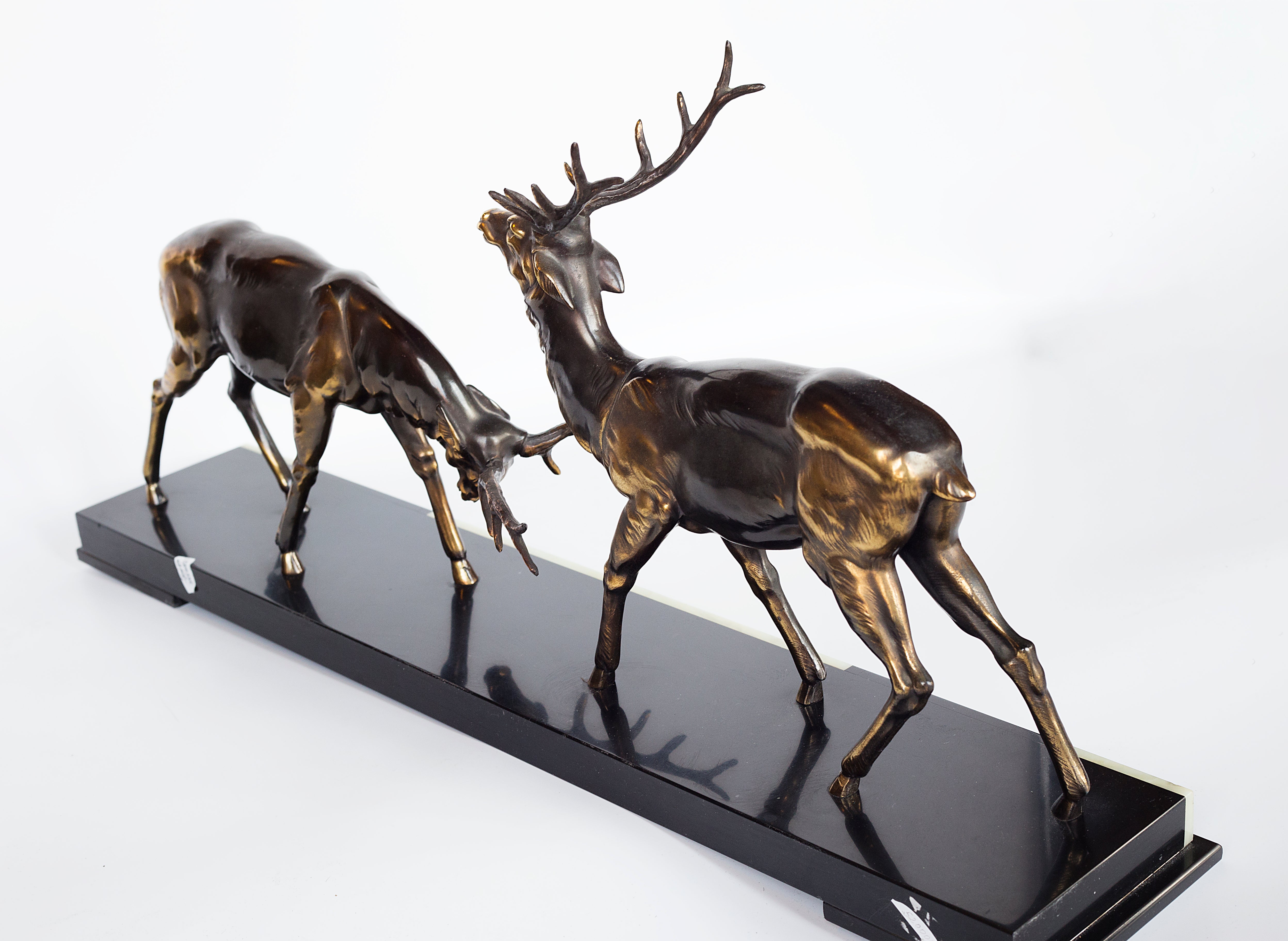 A 1930s Art Deco sculpture by Limousin captures the elegance of two deers poised gracefully atop a striking multi-colored marble base