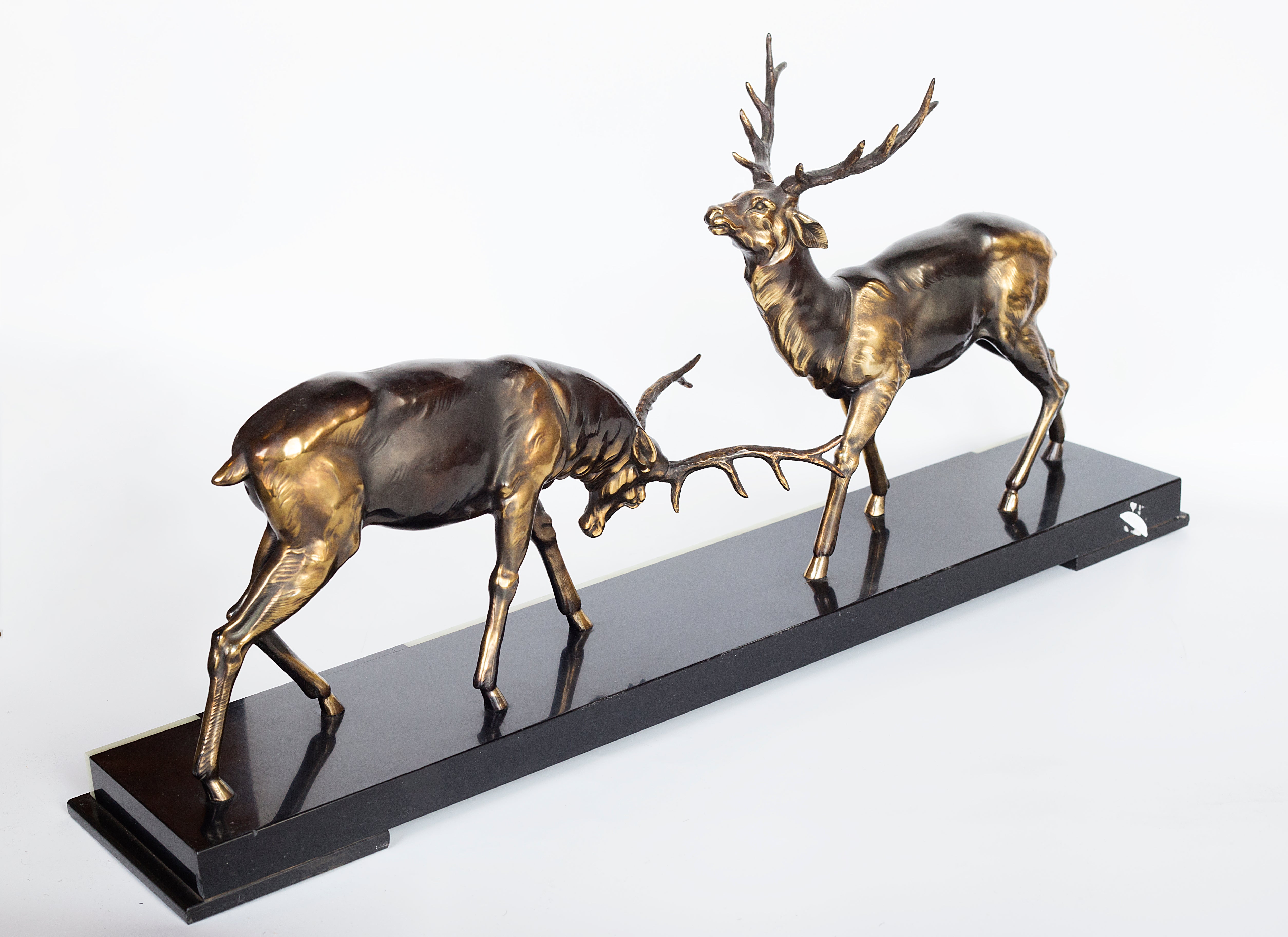 A 1930s Art Deco sculpture by Limousin captures the elegance of two deers poised gracefully atop a striking multi-colored marble base