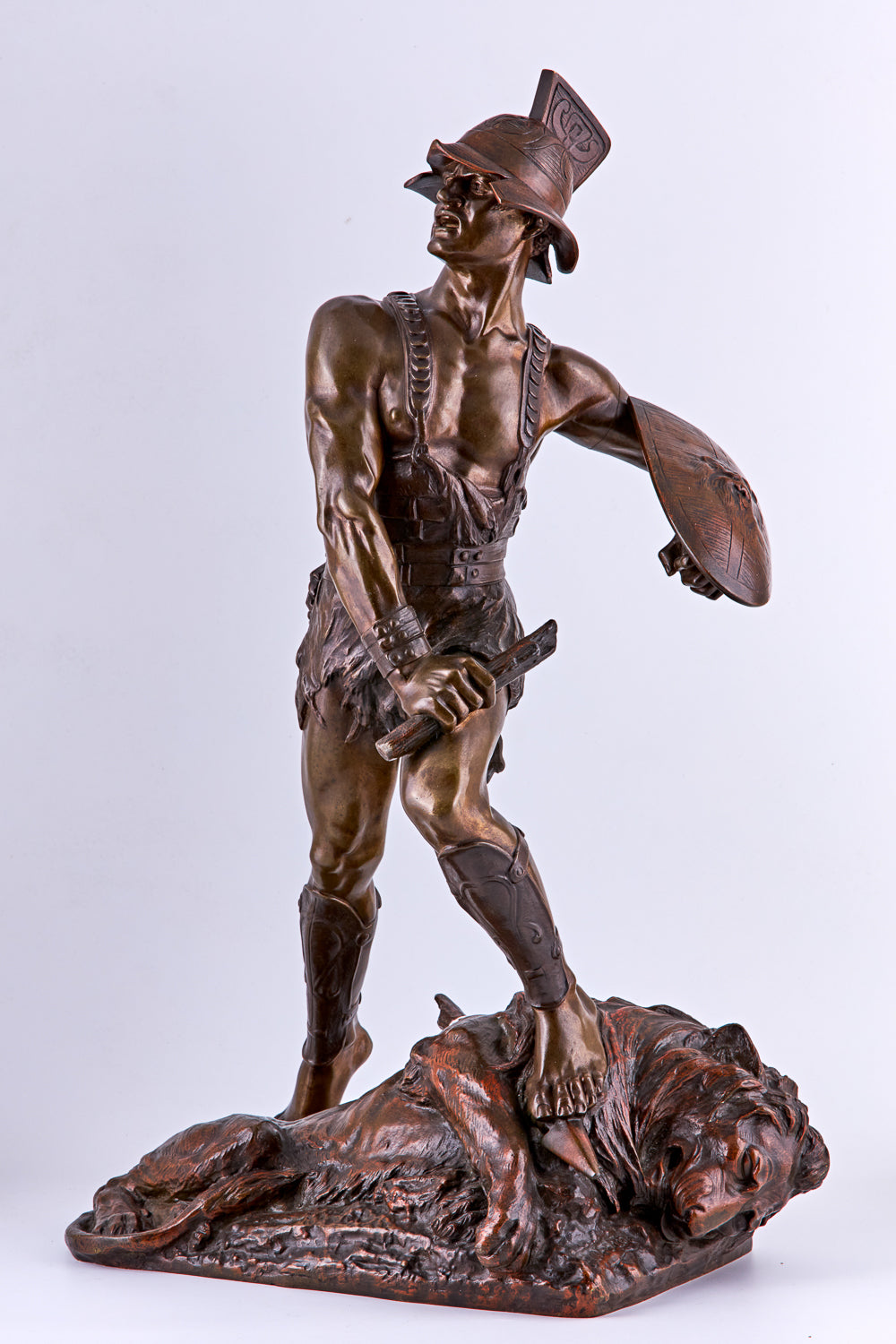 A bronze sculpture by Edouard Drouot, dating from the late 19th century, captures the dramatic moment between a gladiator and a defeated lion
