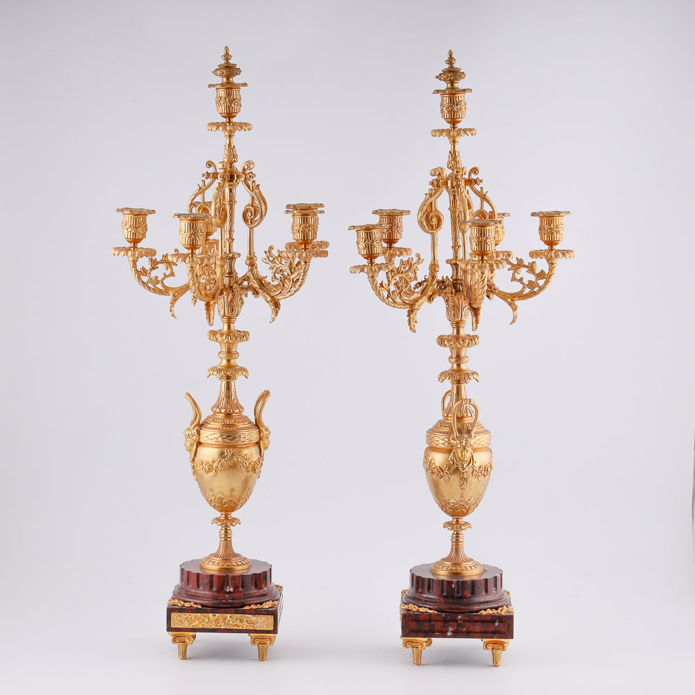 A pair of 19th-century gilt bronze candelabras features a Renaissance-inspired design