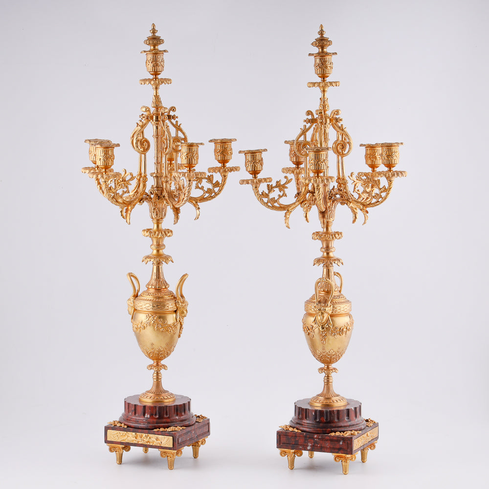 A pair of 19th-century gilt bronze candelabras features a Renaissance-inspired design