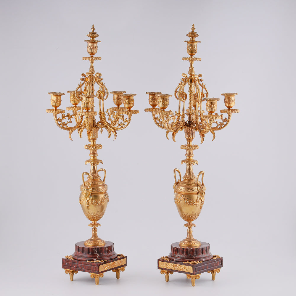 A pair of 19th-century gilt bronze candelabras features a Renaissance-inspired design