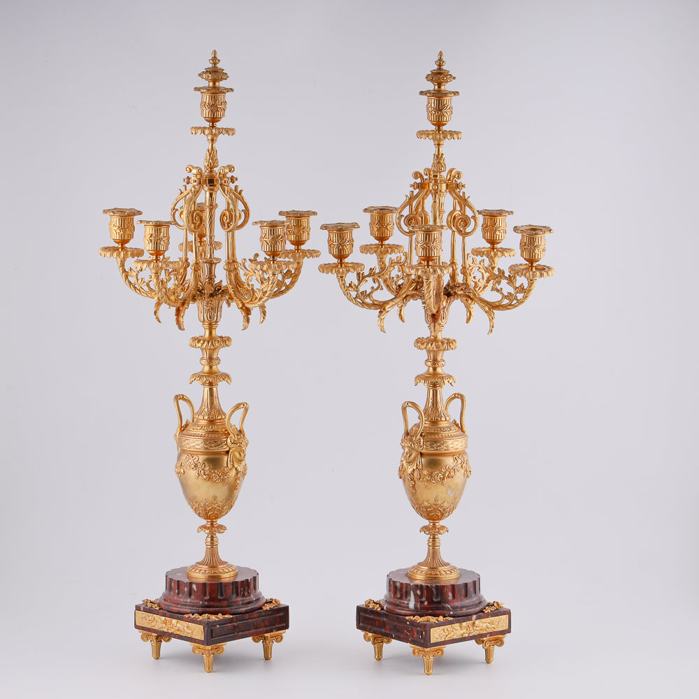 A pair of 19th-century gilt bronze candelabras features a Renaissance-inspired design
