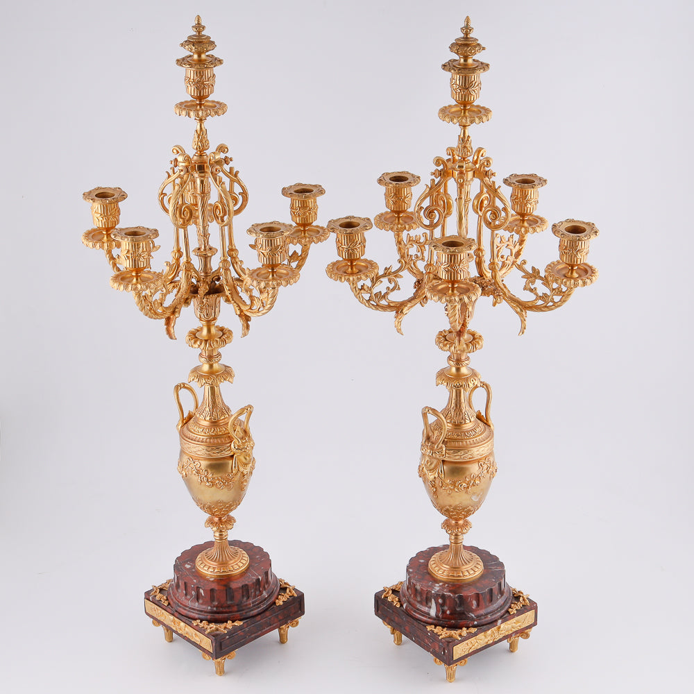A pair of 19th-century gilt bronze candelabras features a Renaissance-inspired design