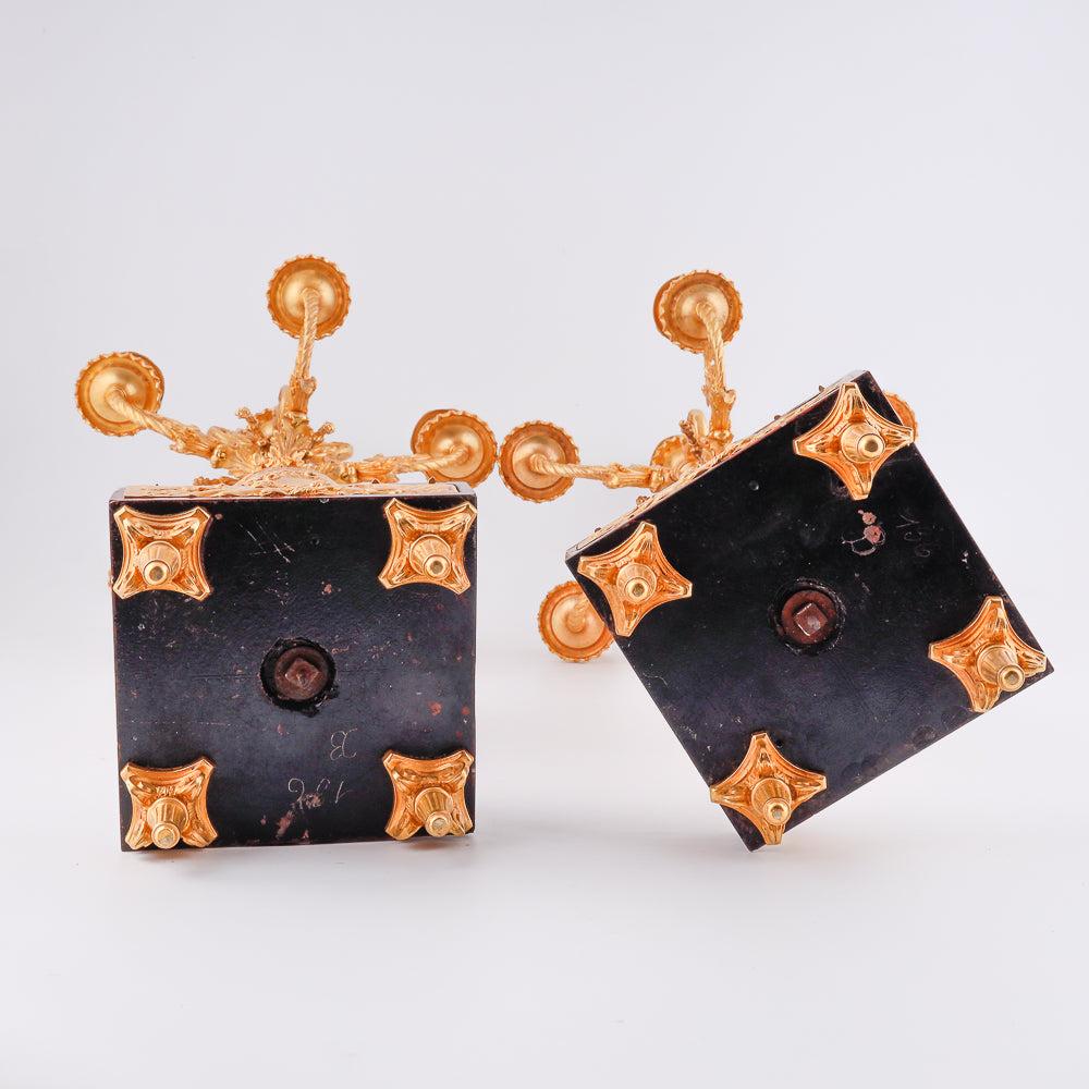 A pair of 19th-century gilt bronze candelabras features a Renaissance-inspired design