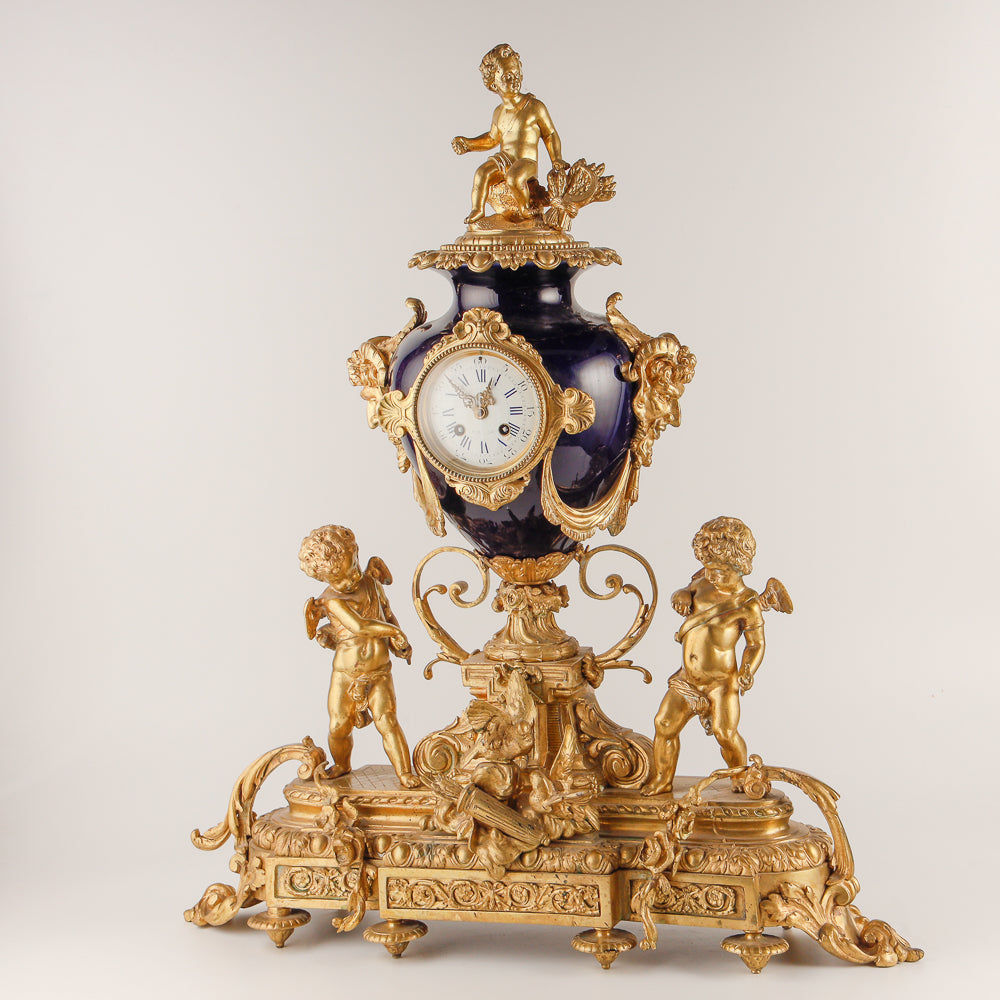 Gran reloj de salón azul cobalto con dos jarrones.