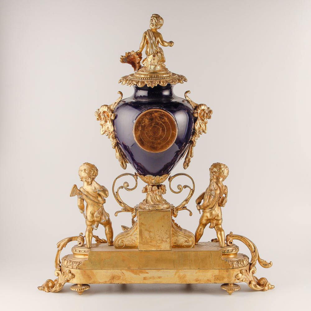 Gran reloj de salón azul cobalto con dos jarrones.