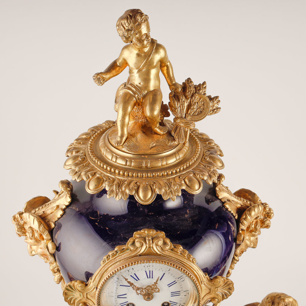 Gran reloj de salón azul cobalto con dos jarrones.