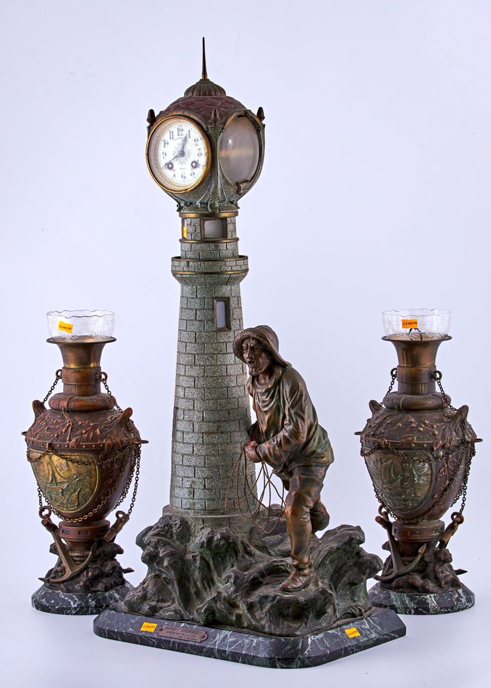 Antique distinguished spelter set captures a captivating maritime scene featuring a lighthouse and a fisherman