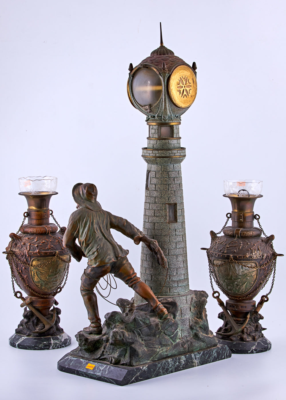 Antique distinguished spelter set captures a captivating maritime scene featuring a lighthouse and a fisherman