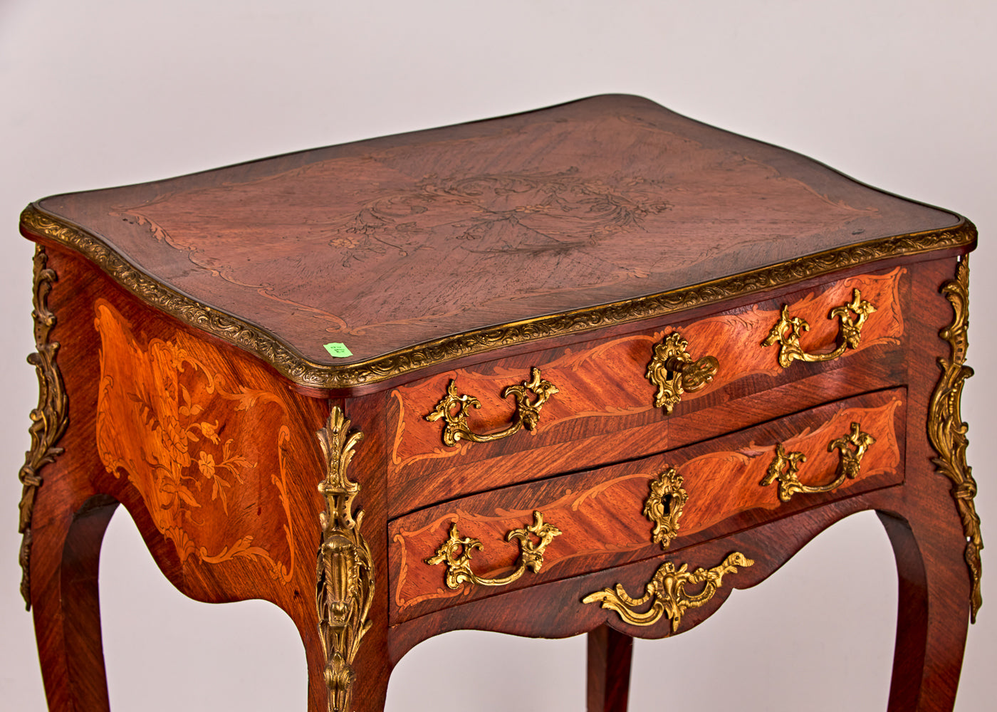 Antique dresser featuring a remarkable blend of treasured wood species with intricate gilt bronze details