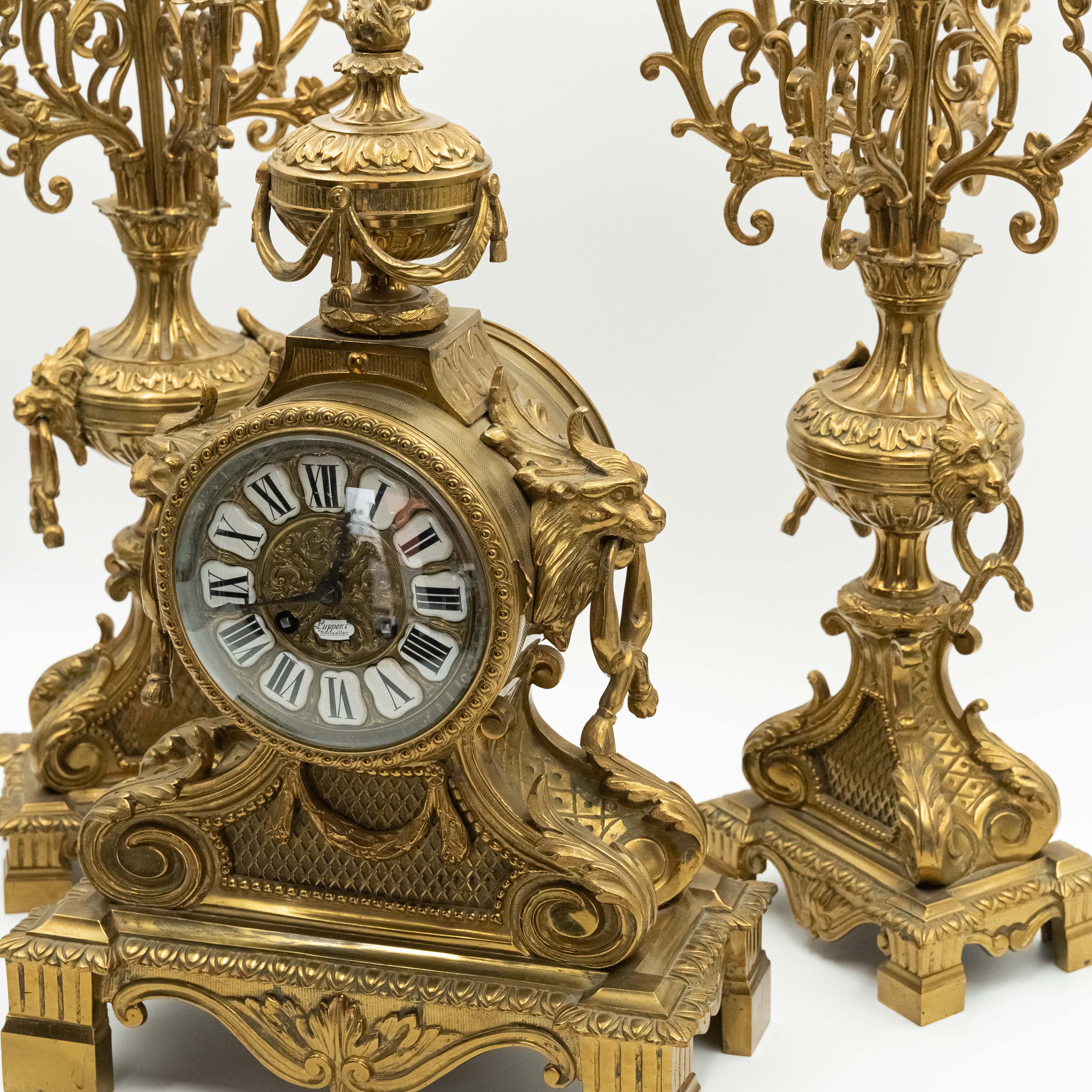 Antiguo reloj de sobremesa de bronce de estilo ecléctico con dos candelabros al estilo de Napoleón III. decoración