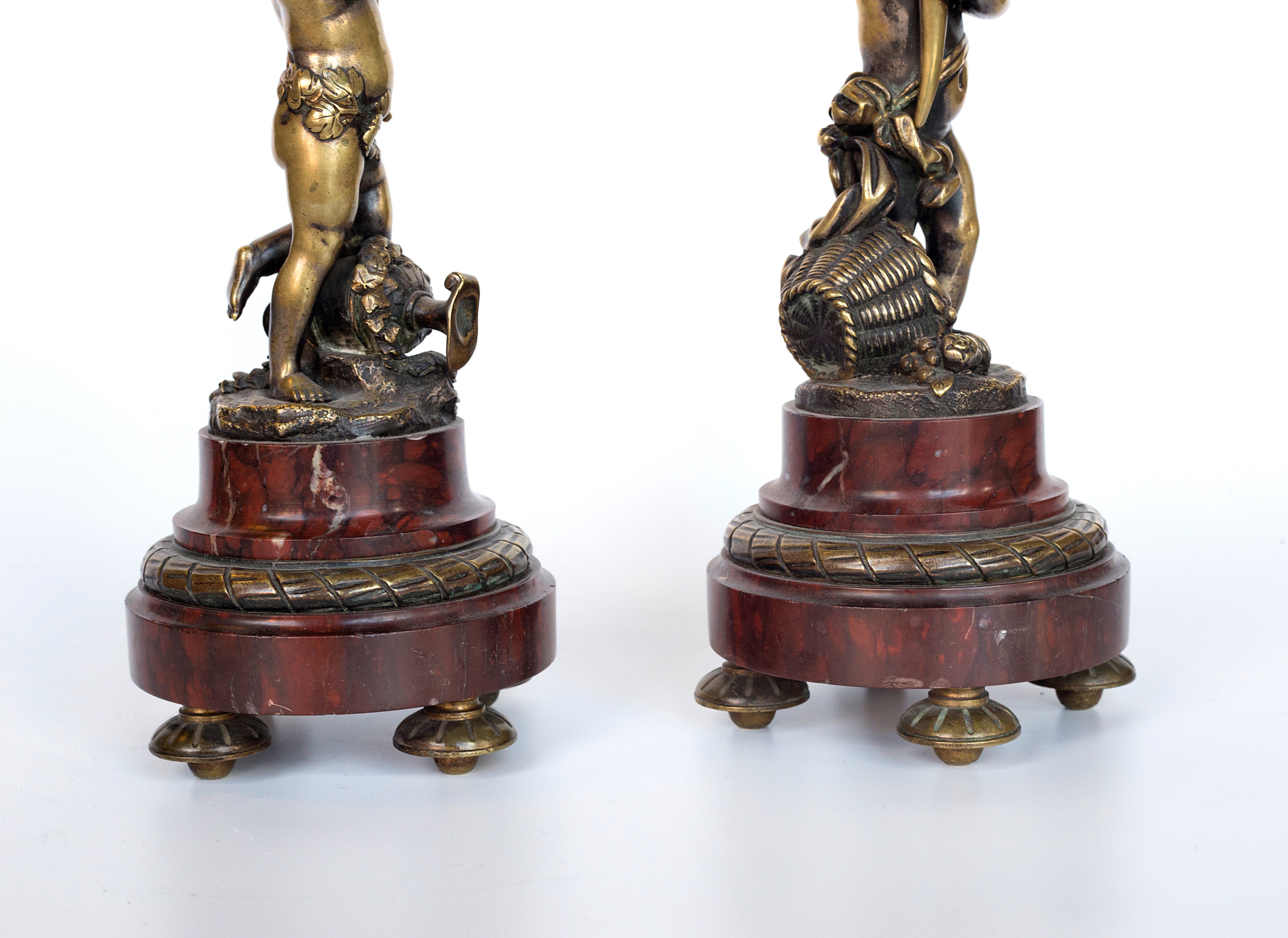 Antique handcrafted bronze clock sits atop a stone plinth, featuring a sculpture of a Putti, inspired by the French Rococo sculptor Clodion (Claude Michel)