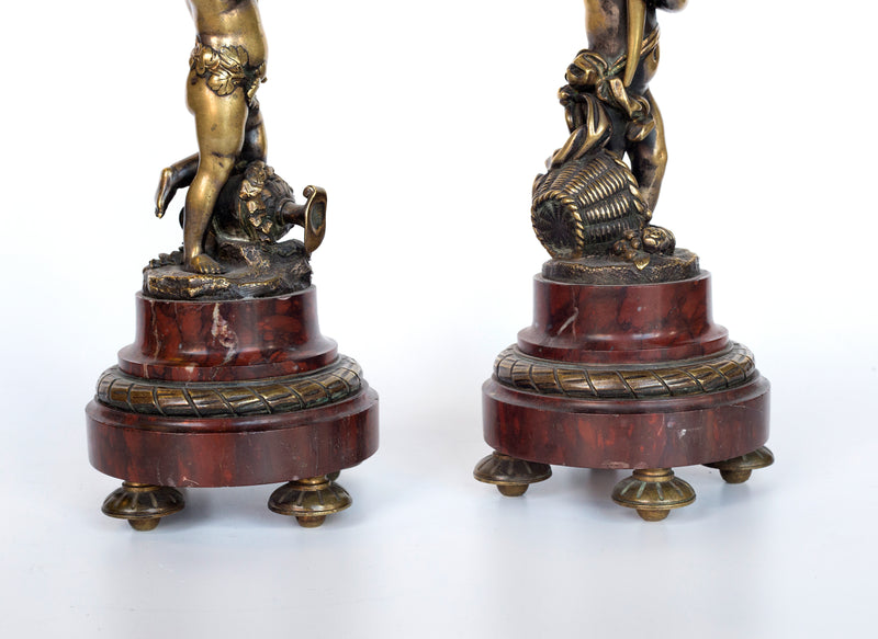 Antique handcrafted bronze clock sits atop a stone plinth, featuring a sculpture of a Putti, inspired by the French Rococo sculptor Clodion (Claude Michel)
