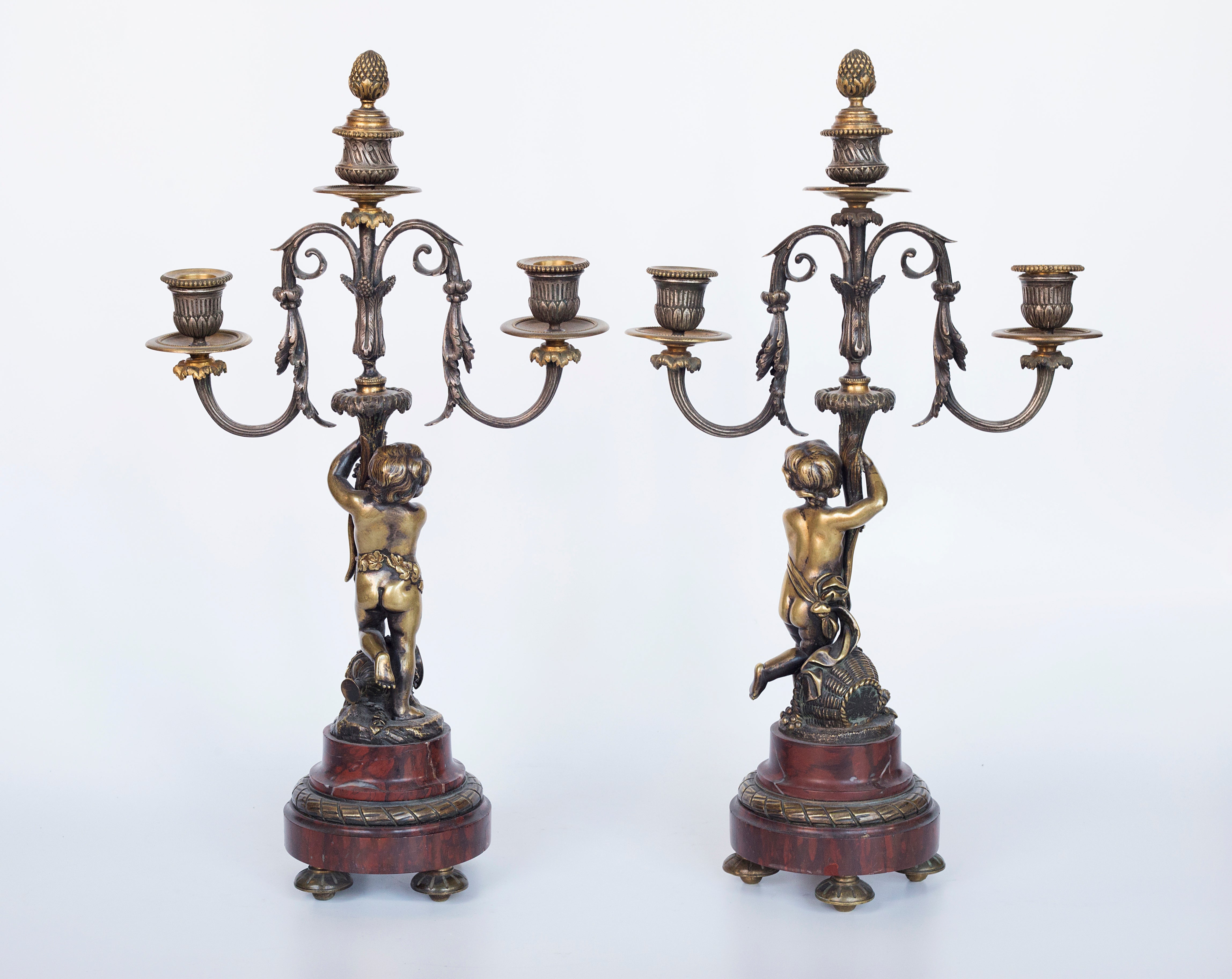 Antique handcrafted bronze clock sits atop a stone plinth, featuring a sculpture of a Putti, inspired by the French Rococo sculptor Clodion (Claude Michel)