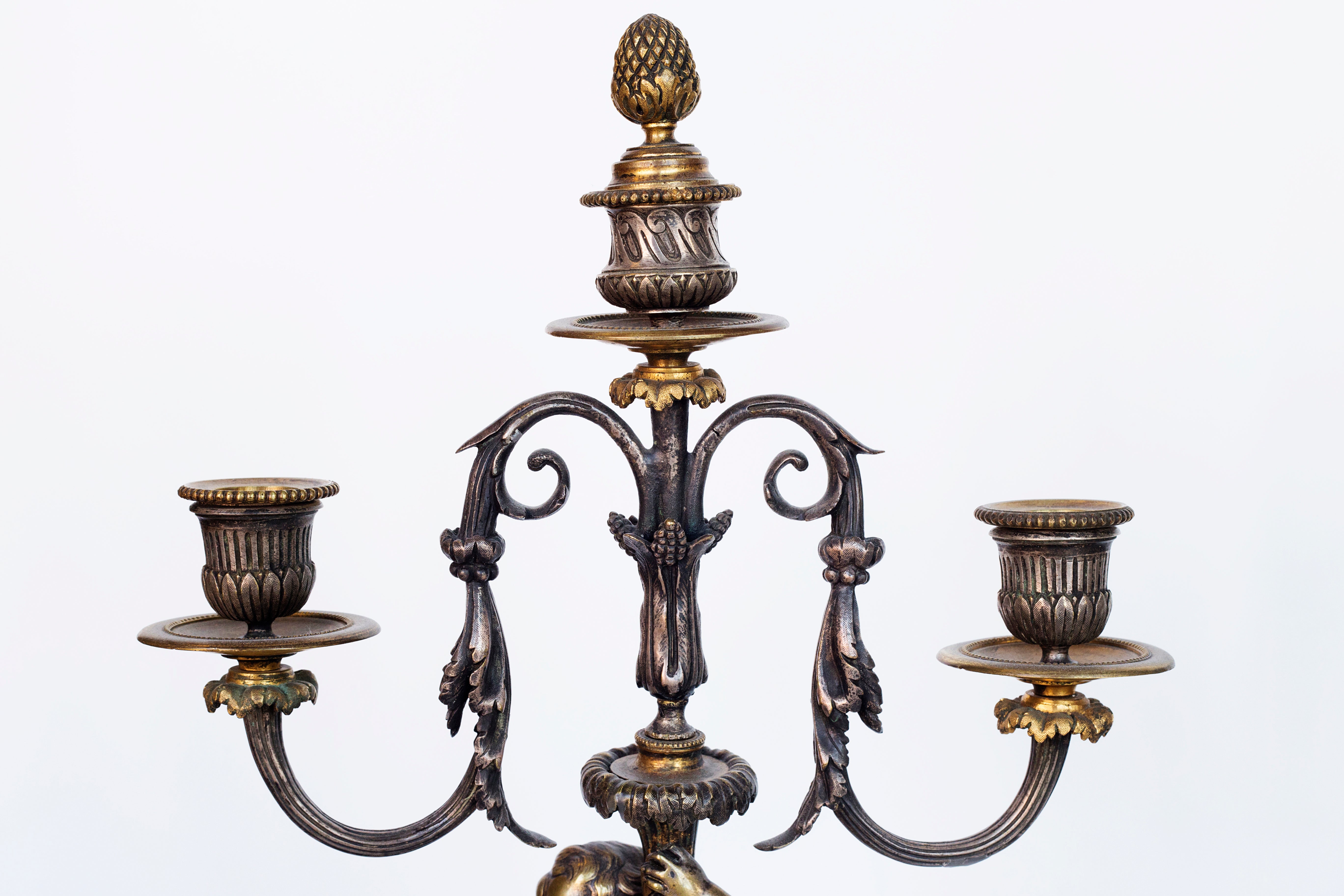 Antique handcrafted bronze clock sits atop a stone plinth, featuring a sculpture of a Putti, inspired by the French Rococo sculptor Clodion (Claude Michel)