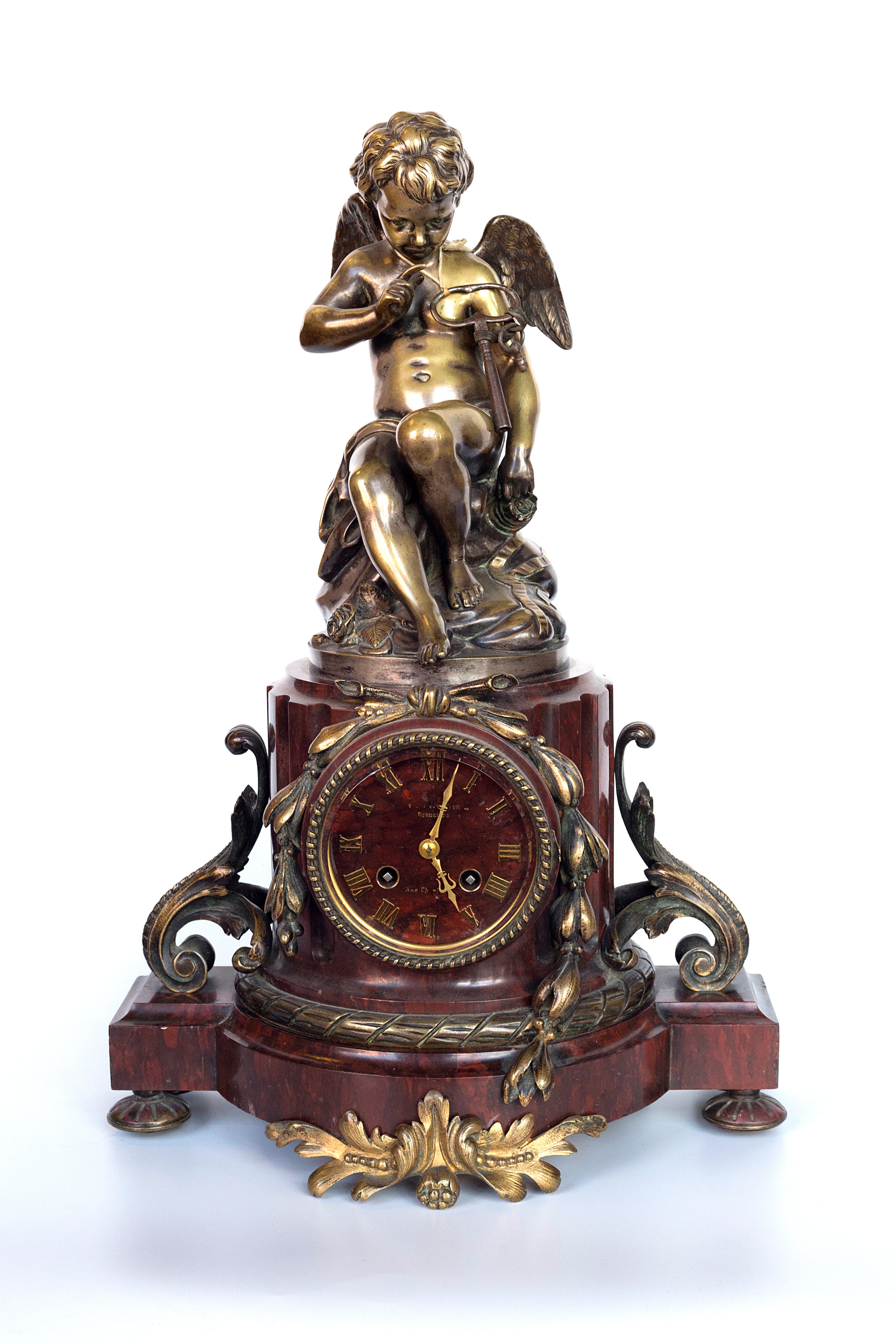 Antique handcrafted bronze clock sits atop a stone plinth, featuring a sculpture of a Putti, inspired by the French Rococo sculptor Clodion (Claude Michel)