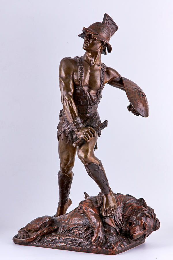 Escultura de bronce de Edouard Drouot de un gladiador y un león derrotado.