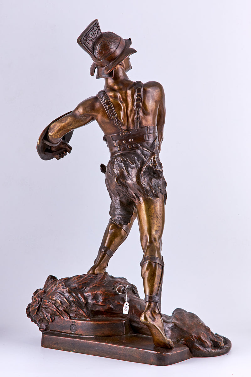 Escultura de bronce de Edouard Drouot de un gladiador y un león derrotado.