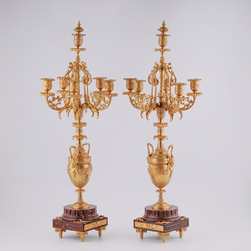 Pair of antique candelabras on a marble plinth