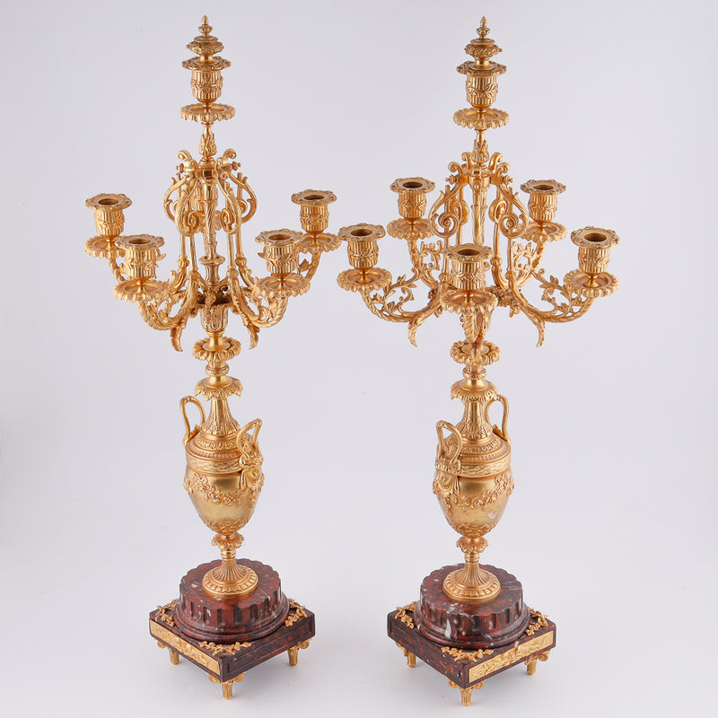 Pair of antique candelabras on a marble plinth