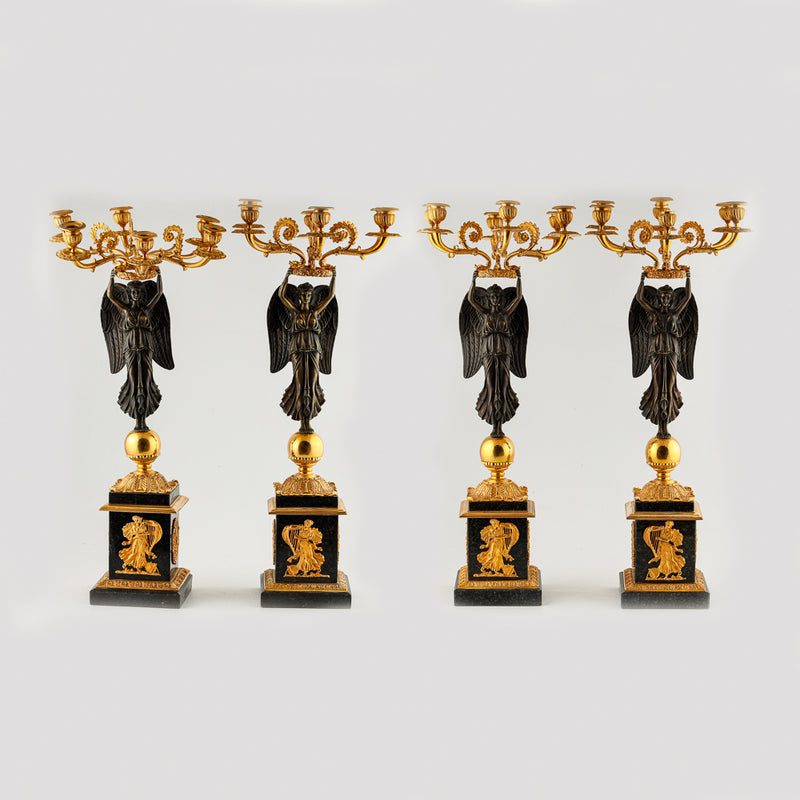 Four antique candelabras with a statue of winged victory