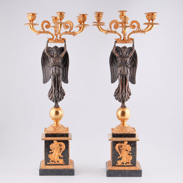 四個古董燭台，上面有一尊帶翅膀的勝利雕像