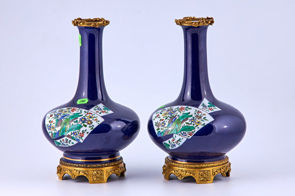 Pareja de jarrones de porcelana con elementos decorativos de bronce.