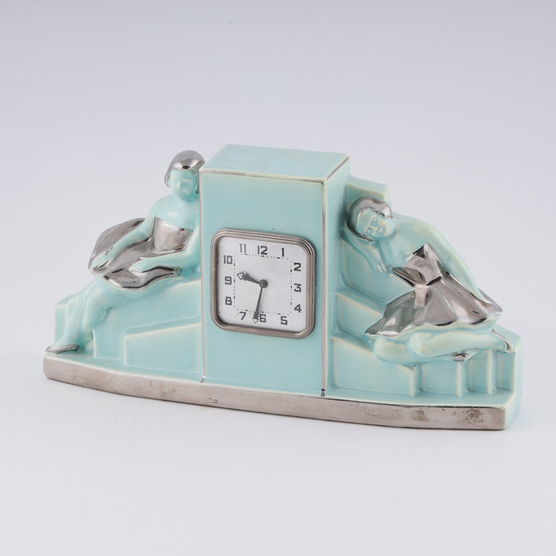 Fajance Art Deco clock shaped in a pedestal form with two elegant ballerinas sitting gracefully at each side