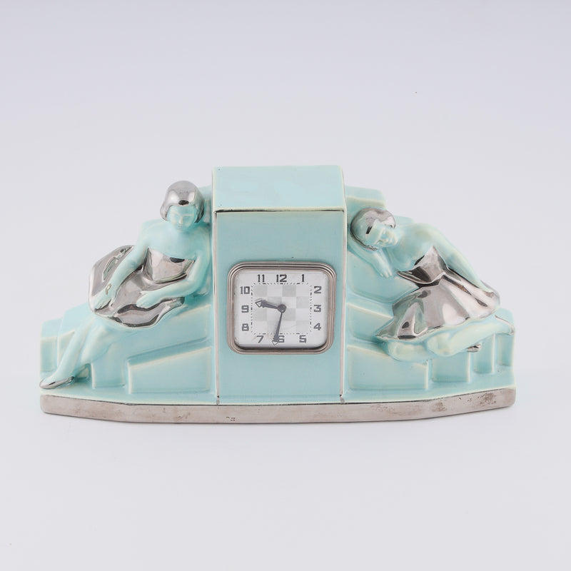Fajance Art Deco clock shaped in a pedestal form with two elegant ballerinas sitting gracefully at each side