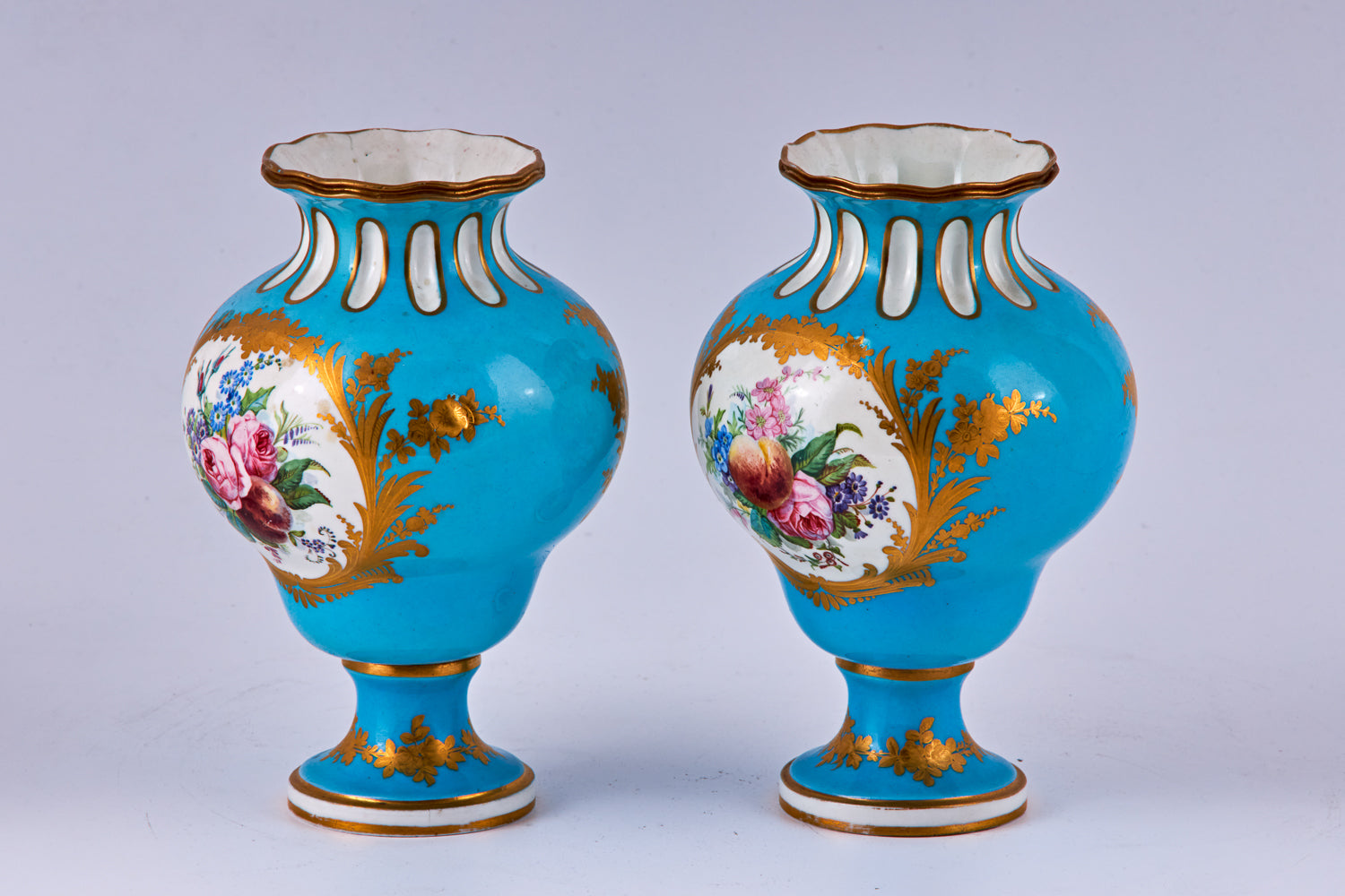 Pareja de jarrones de porcelana azul de Sevres pintados a mano con decoración policromada