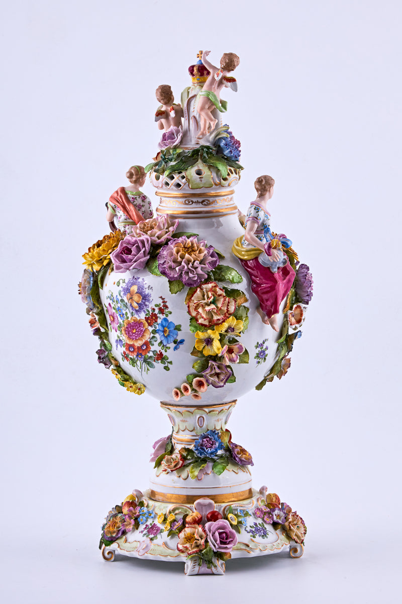 Jarrón de porcelana con flores de estuco y motivos rococó.