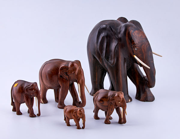 Vintage set of five wooden elephants with ivory tusks
