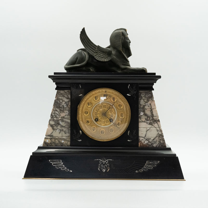 Antique marble mantel clock with an Egyptian motif decorated with a winged sphinx on top