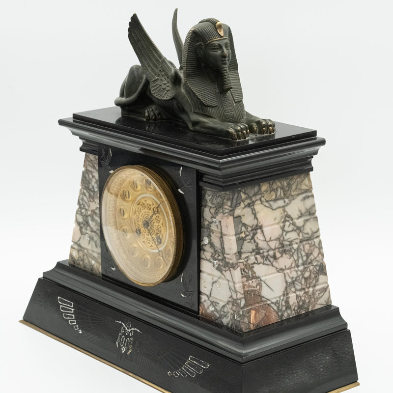 Antique marble mantel clock with an Egyptian motif decorated with a winged sphinx on top
