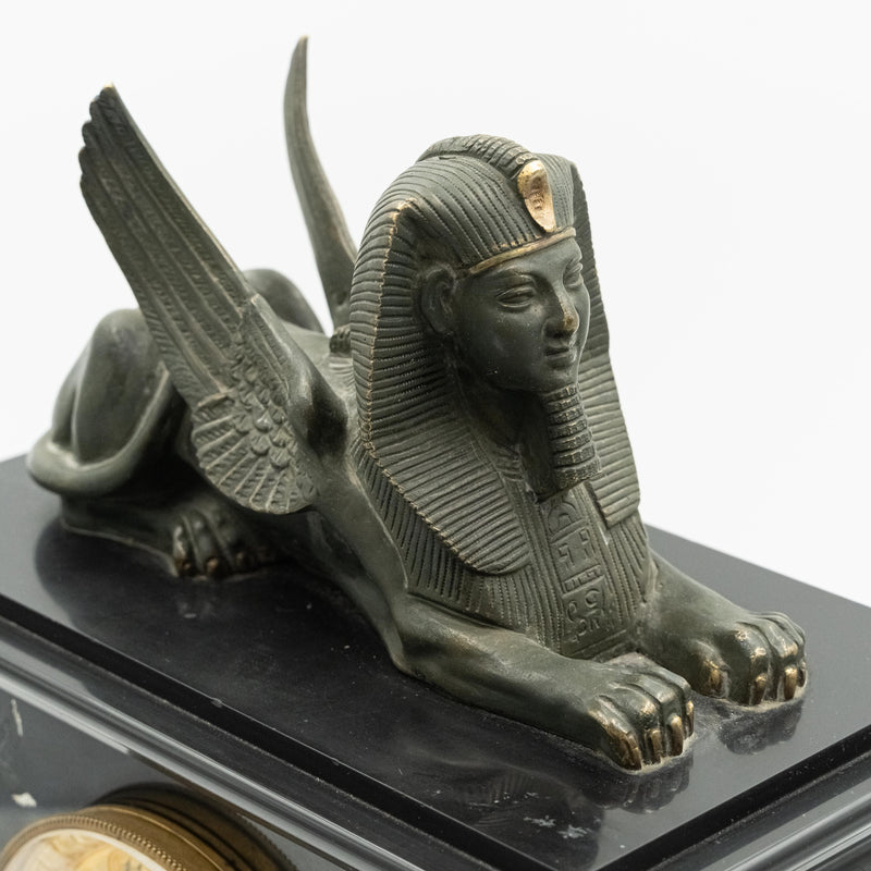 Antique marble mantel clock with an Egyptian motif decorated with a winged sphinx on top