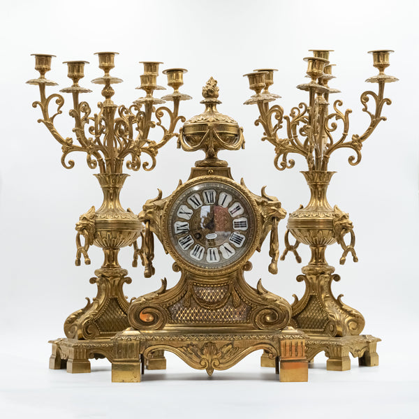 Antiguo reloj de sobremesa de bronce de estilo ecléctico con dos candelabros al estilo de Napoleón III. decoración